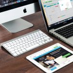 A sleek office desk setup featuring Apple devices